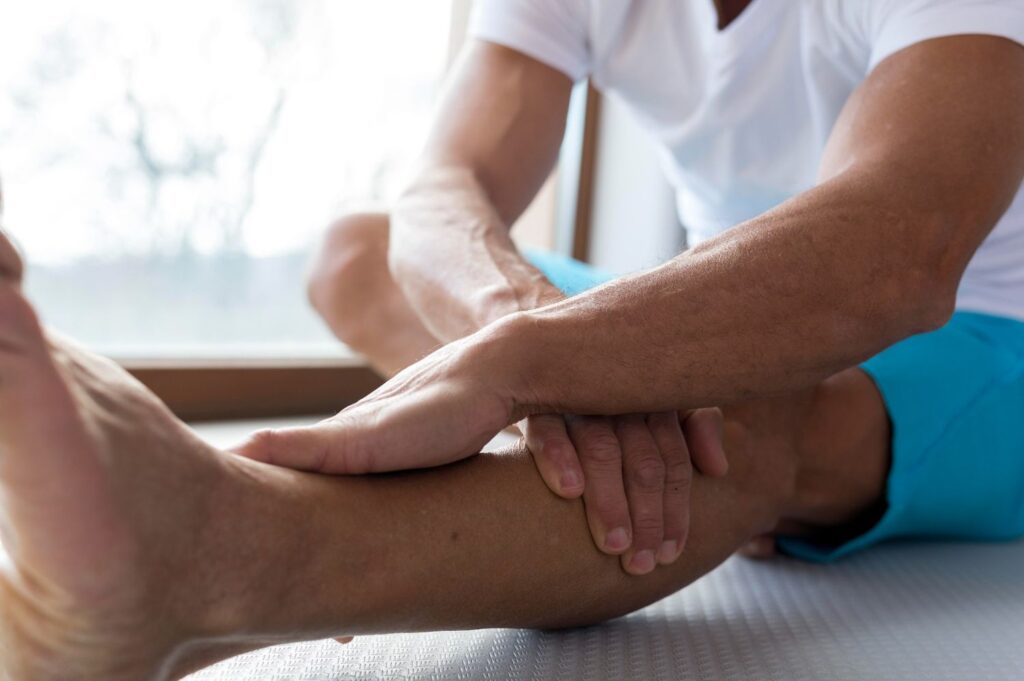 Person receiving manual chiropractic adjustment or soft tissue therapy on the calf and lower leg.