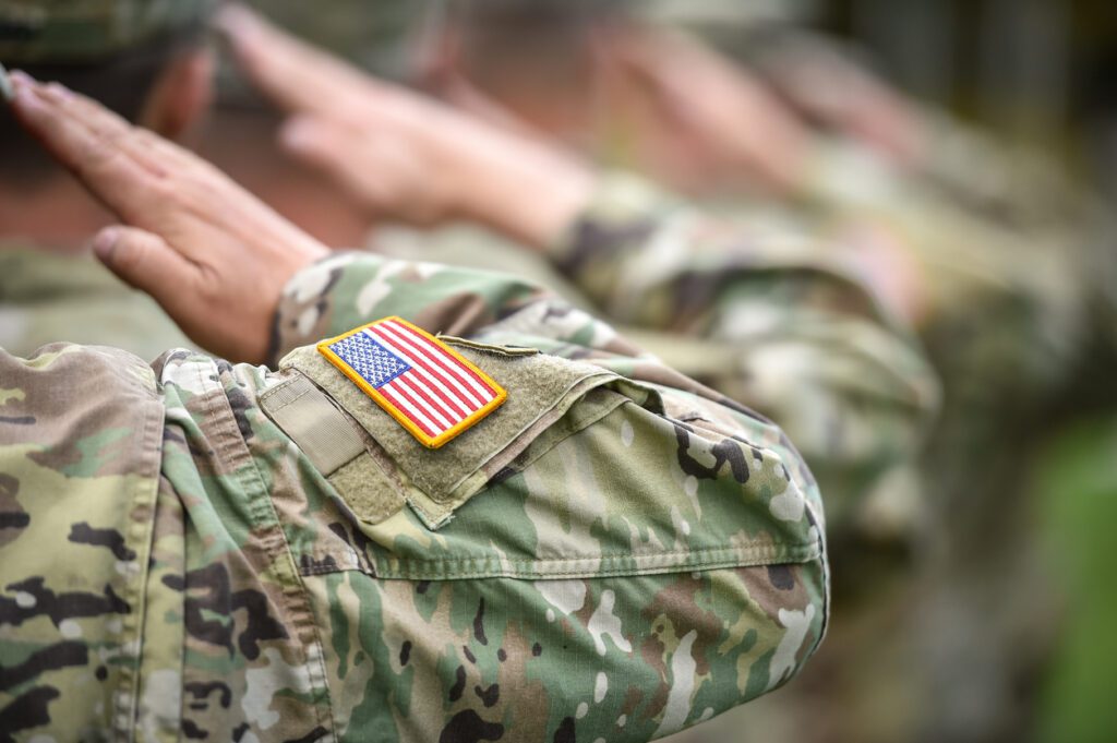 Close-up of a soldier's arm in a camouflage uniform with an American flag patch.