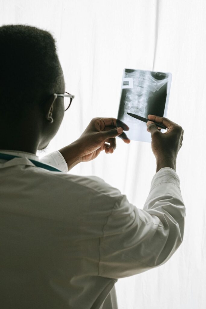 A chiropractor examines spinal imaging
