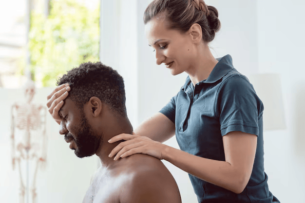 A chiropractor performing a neck adjustment on a male client.